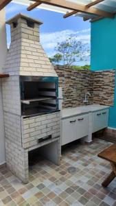 a brick oven with a sink in a patio at Casa Silandia, tu casa en Búzios in Búzios