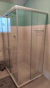 a shower stall with glass doors in a bathroom at Casa Silandia, tu casa en Búzios in Búzios