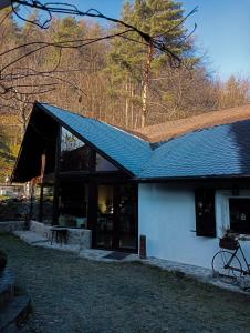 a house with a black roof and a building at Grădina cu povești in Brezoi