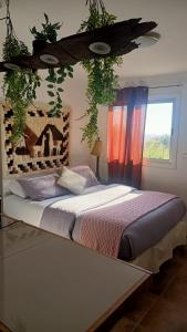 a bedroom with a bed with plants above it at Cabañas Toto Península Beach in Totoralillo