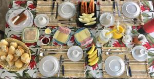 a table topped with plates and bowls of food at Pousada Hostal das Estrelas in Praia do Frances