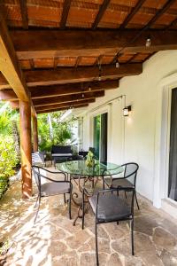 un patio con tavolo in vetro e sedie di Villas Xaguar by PlayaSky a Playa del Carmen