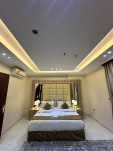 ein Schlafzimmer mit einem großen Bett mit zwei Tischen und einem Fenster in der Unterkunft قصر الذهب للوحدات السكنية المخدومة in Dschidda
