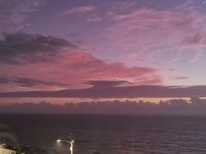 a sunset over a body of water with a lighthouse at Pra la Vue in Durban +6 photos