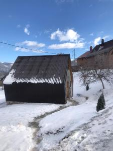 an old barn with snow on the ground at Chalet Wood Magic in Kolašin