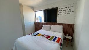 Dormitorio con cama con escrito en la pared en Aconchegante Apt na Praia de Pajuçara !Gales 907 com piscina na cobertura e vaga de garagem - Gales de Pajuçara 907-Wifi 500 mg-Pertinho de Tudo, en Maceió