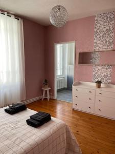 a bedroom with a bed and a dresser and a mirror at Les Maisons d'Auré in Putanges