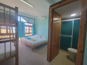 Cielo Hostel في تاجانجا: غرفة نوم بسرير ودش ومرحاض