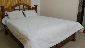 a large bed with white sheets and pillows on it at Greenland Homestay in Manimala +10 photos