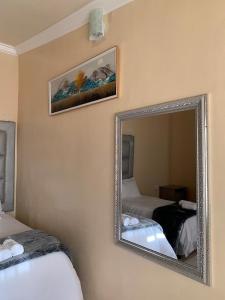 - un miroir sur le mur d'une chambre avec 2 lits dans l'établissement Mudix Royal Palace Guest Lodge, à Musina