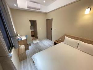 FengshanにあるShuntai Innのベッドと窓が備わる小さな客室です。