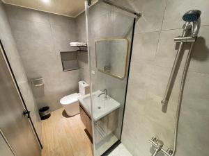 a bathroom with a shower and a sink and a toilet at Shuntai Inn in Fengshan