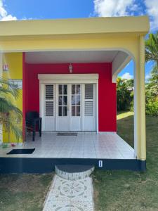 ein Haus mit einer roten und gelben Wand in der Unterkunft Gîte Allée des Cocotiers in Saint-François