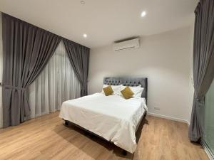 1 dormitorio con 1 cama con sábanas blancas y almohadas de oro en Quill Residence KL by Bamboo Hospitality, en Kuala Lumpur