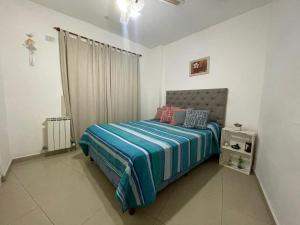 1 dormitorio con 1 cama con edredón azul en SORRENTO Céntrico en Villa Carlos Paz
