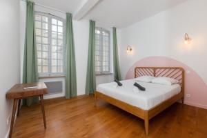 1 dormitorio con cama, mesa y ventanas en La Terrasse du Saint-Didier, en Aviñón