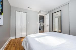 1 dormitorio con cama blanca y espejo en The Bright Retreat in Andersonville, en Chicago