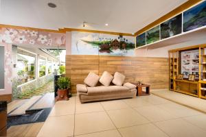 Anachal的住宿－Star Emirates Luxury Resort and Spa, Munnar，客厅配有沙发和墙上的绘画