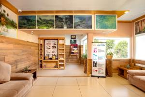 a living room with couches and a large window at Star Emirates Luxury Resort and Spa, Munnar in Anachal