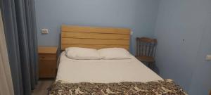a bedroom with a bed and a wooden headboard at saxli tyis piras in Bakuriani
