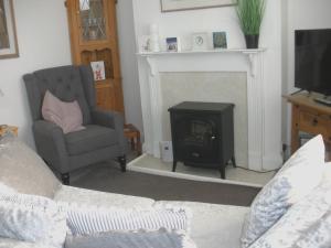 a living room with a fireplace and a chair at Trent Cottage in Newark upon Trent