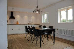 a kitchen with a black table and black chairs at Modern Country Apartment in Borlänge