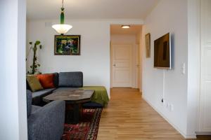 uma sala de estar com um sofá e uma mesa em Modern countryside apartment em Borlänge