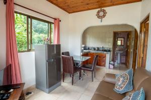 a kitchen and living room with a refrigerator and a table at Tropical Beach House in Grand Anse