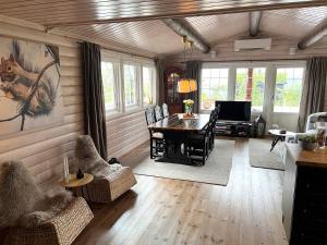sala de estar con mesa, sillas y TV en Cozy cabin on Lifjell with jacuzzi close to cross-country trails and hiking trails, en Lifjell