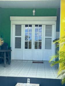 eine Eingangstür eines Hauses mit einem Tisch in der Unterkunft Gîte Allée des Cocotiers in Saint-François + 16 Fotos