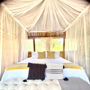 a bedroom with a white bed with a canopy at Nuscaa Boutique Tree House & Spa in Puerto Morelos