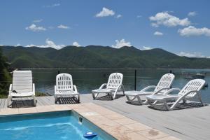 a group of chairs sitting on a deck next to a swimming pool at Terrazas Del Lago in Coronel Moldes