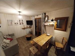 a small living room with a table and a couch at VALLOIRE, studio 22m2, tout à pied, remontées mécaniques à 100m in Valloire