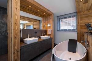 a bathroom with two sinks and a large tub at Chalet ORUS - Tirol Kärnten in Irschen