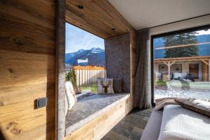 a bedroom with a large window with a mountain view at Chalet ORUS - Tirol Kärnten in Irschen