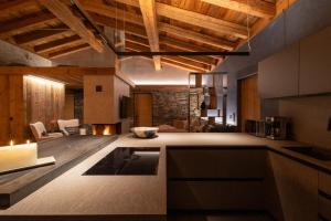 a kitchen with wooden ceilings and a living room at Chalet ORUS - Tirol Kärnten in Irschen