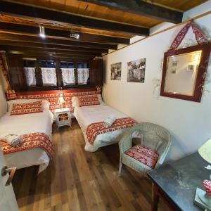 um quarto com três camas, uma mesa e um espelho em El Arcángel de Santillana del Mar em Santillana del Mar