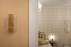 een kamer met een bed met een bord aan de muur bij Casa dei Liuti in Alghero