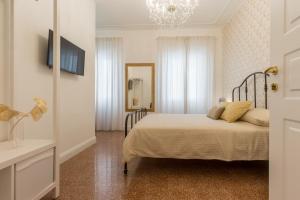 een slaapkamer met een bed en een kroonluchter bij Casa dei Liuti in Alghero