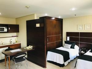 a hotel room with a bed and a desk and a kitchen at Delicioso flat em área nobre in São Paulo