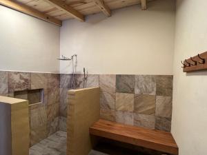 a bathroom with a shower with a bench in it at Lunada Glamping in Mazamitla