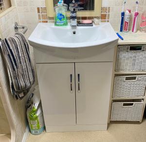 een badkamer met een wastafel en een witte kast bij Bobbys Bolthole2 in Heysham +19 foto's