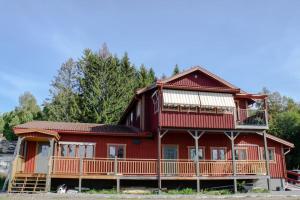 una grande casa rossa con un ampio balcone di Modern countryside apartments a Borlänge