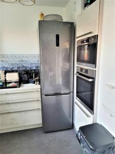 un frigorifero in acciaio inossidabile in cucina di Magnifique appartement 10 min de Paris - Parking privée Gratuit a Chevilly-Larue