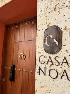 una puerta a una casa nova señal en un edificio en Casa Noa Colonial Rooms By SOHO en Cartagena de Indias