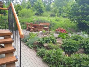 a garden with a bench and some flowers at Srub Javorná - apartmány Šumava in Javorná