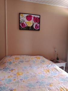 Pousada Belvedere في تيباجي: غرفة نوم بسرير مع لوحة على الحائط