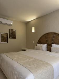 1 dormitorio con 1 cama blanca grande en una habitación en Casa Noa Colonial Rooms By SOHO, en Cartagena de Indias