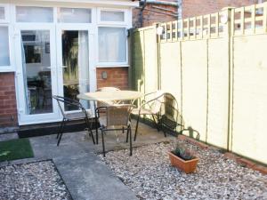 a patio with a table and chairs and a fence at Trent Cottage in Newark-on-Trent