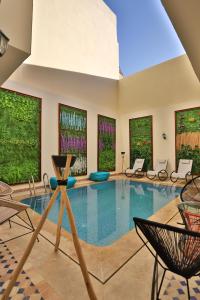 a large swimming pool with chairs and windows at Darif's Riad Fes & Spa in Fez